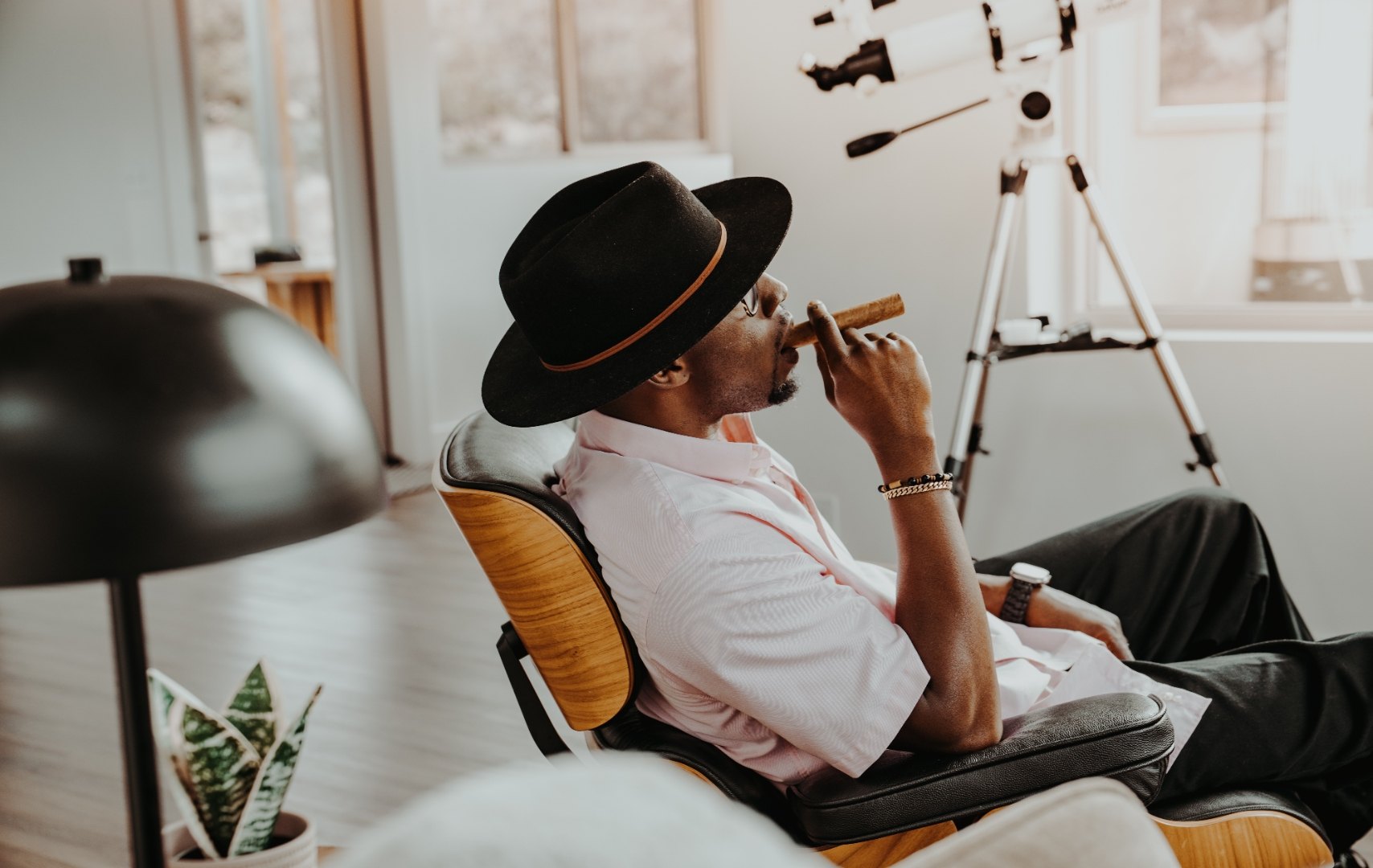 Profile of Ian Bennett drawing on a cigar in a leather lounge chair