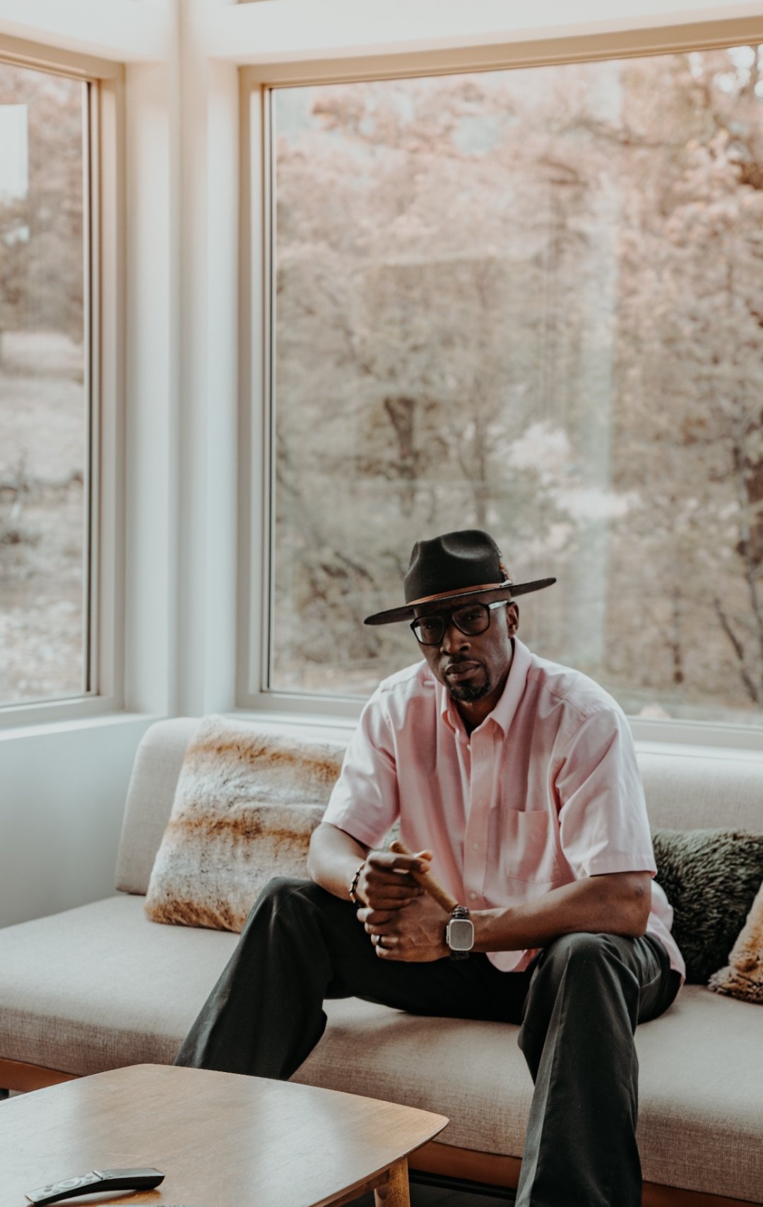 Portrait of Ian Bennett in a wide brim hat holding a cigar