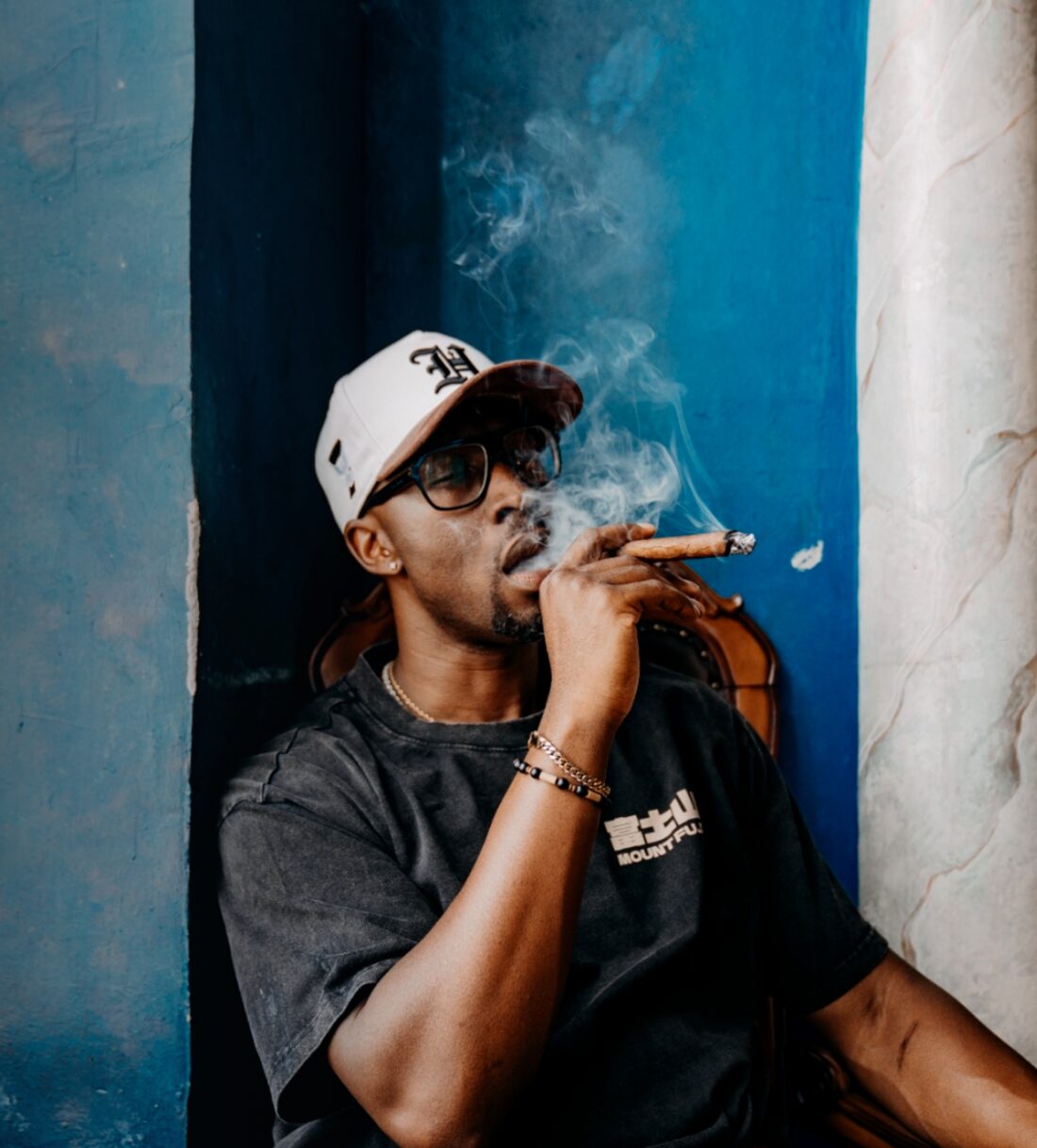 Ian Bennett exhaling cigar smoke in the lounge